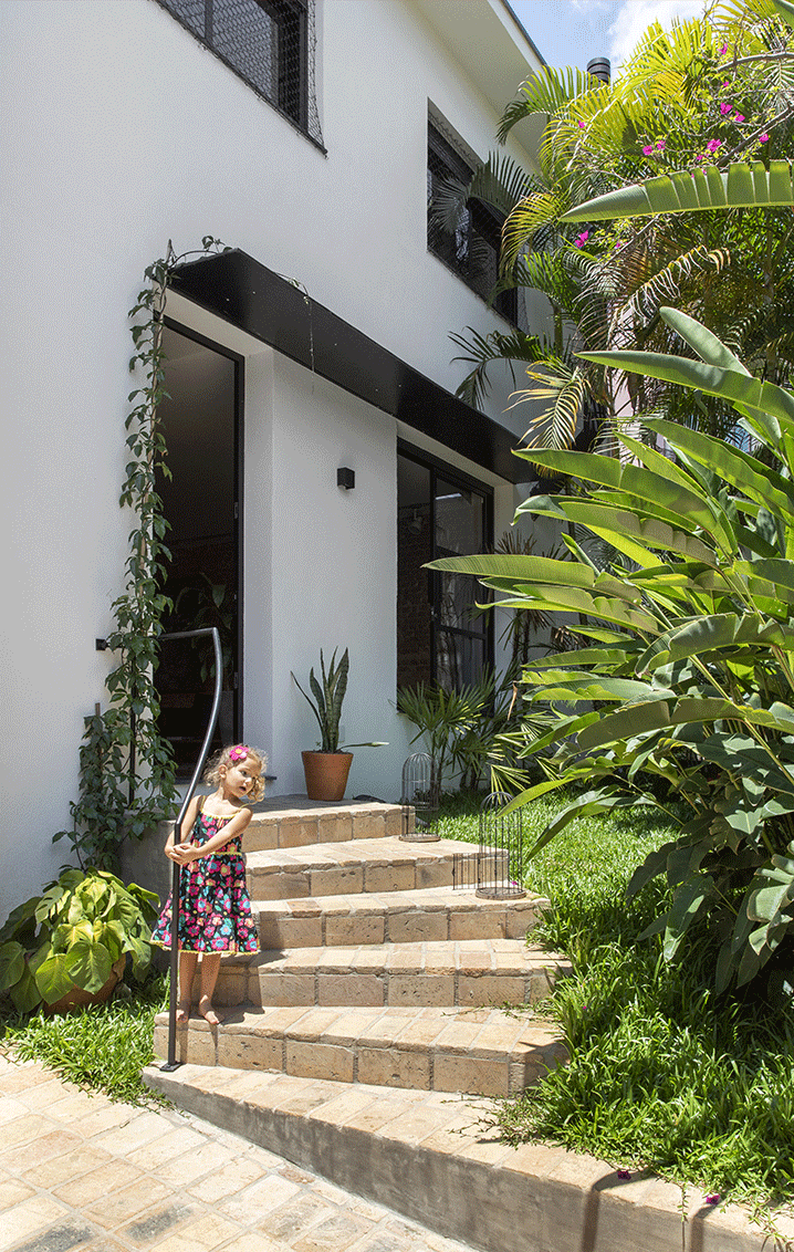 Casa Isabelle e Fernando, entrada da casa, piso lajota de tijolo, serralheria preta, jardim.