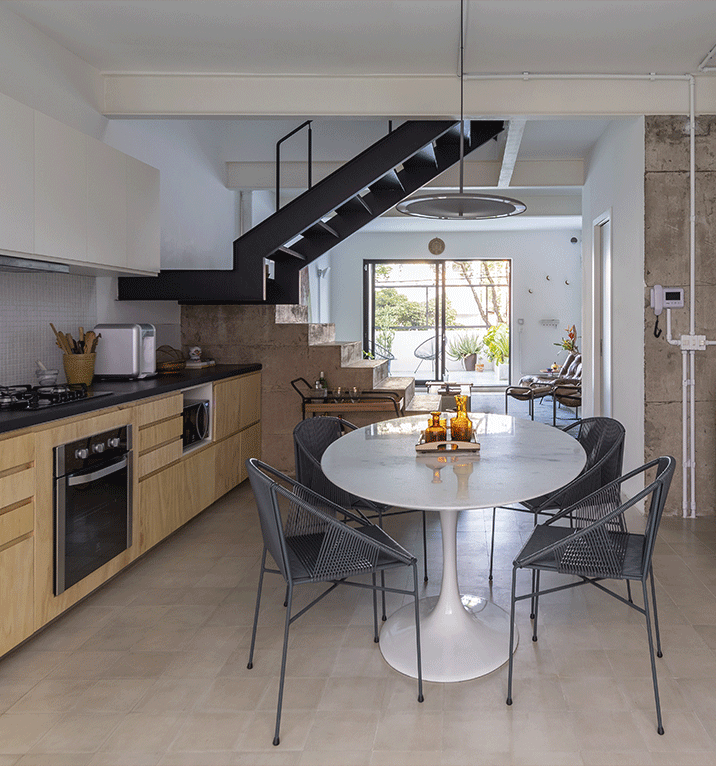 Casa do Marcos e da Júlia, cozinha integrada, mesa de jantar oval, ladrilho hidraulico cinza, escada de concreto aparente.