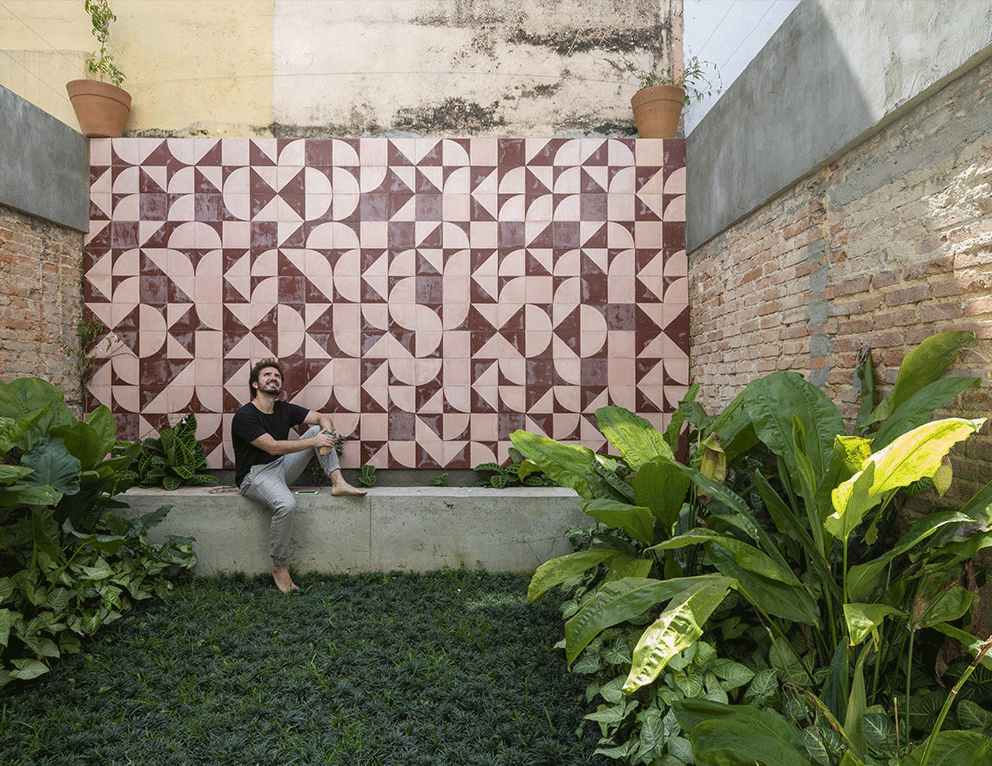 Casa do Marcos e da Júlia, terraço verde, plantas, grama, muro de painel de ladrilho hidráulico, banco de concreto aparente.