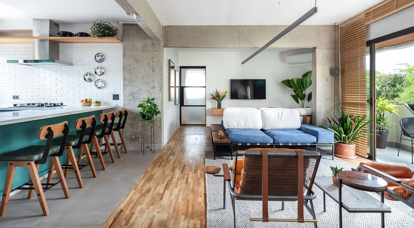Sala integrada do Apartamento Gomes de Carvalho, com piso de madeira, sofá azul e pilares de concreto aparente, na Vila Olímpia