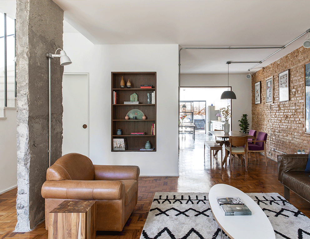Casa Isabelle e Fernando, sala de estar e jantar, poltrona, mesa, taco de madeira, nicho para livros, pilar descascado de concreto, tijolinho aparente.