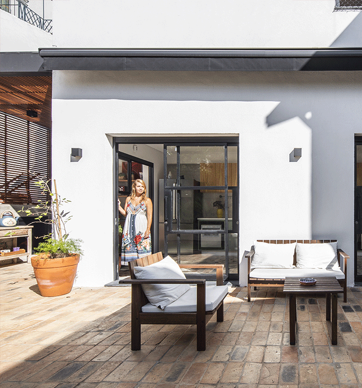 Casa Isabelle e Fernando, patio externo, portas de serralheria, varanda de estar, piso de lajota de tijolos.